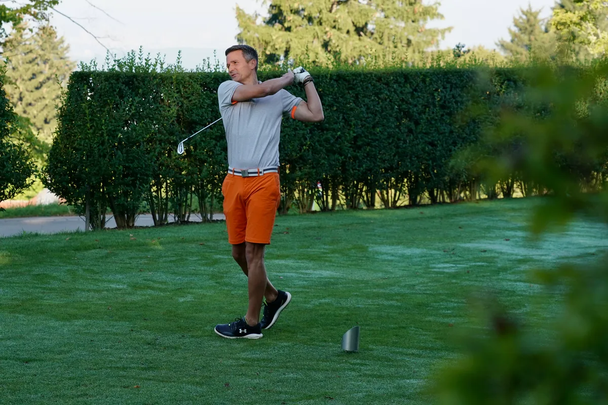 Sportmoderator Paddy Kälin erholt sich noch von einer Armverletzung. Ein Mann steht nach einem Golfabschlag dynamisch auf einer Wiese.